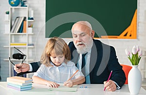 Pupil child lesson. School senior teacher. Education concept. Old grandfather teacher with schoolboy in classroom.