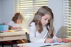 Pupil in classroom at school. Education, elementary school, learning and people concept - group of school kids with pens