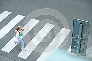 Pupil crossing crosswalk and going to school outdoors in city