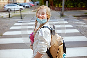 Pupil crossing crosswalk and going to school outdoors in city