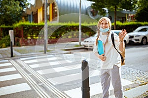 Pupil crossing crosswalk and hand waving outdoors in city