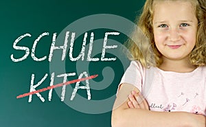 Pupil in front of a blackboard with the German words: Schule statt Kita (school instead of daycare) photo