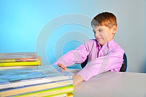 The pupil pushes the textbooks off with his hands, the tortured schoolboy does not like to learn photo