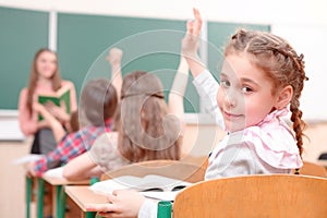Pupil raising hand turned away from teacher