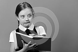 Pupil in school uniform with braid. Girl writes in notebook