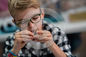 Pupil in school working with electronics component at robotics classroom.