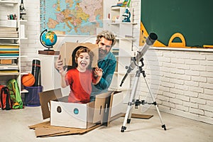 Pupil studies astronomy with funny teacher. Pupil enjoy time with teacher father. Child playing with paper rocket.