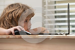 Pupil using computer. Child learning to use computer at elementary school. Portrait of concentrated kid surfing the net