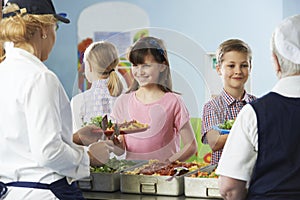 Pupils Being Served With Healthy Lunch In School Canteen photo