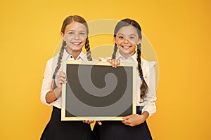 Pupils community. School schedule. School announcement concept. Check this out. School girls cute pupils hold blackboard