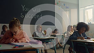 Pupils learning in classroom. Female and male students sitting at desks