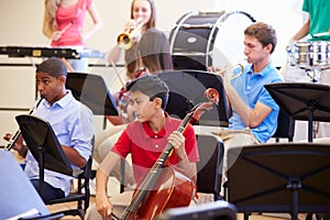 Pupils Playing Musical Instruments In School Orchestra photo