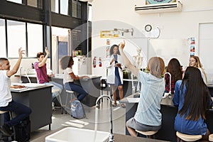 Pupils raising hands in a high school science lesson