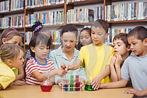 Pupils and teacher doing science in library