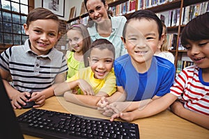 Pupils and teacher in the library using computer