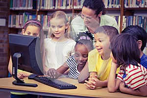 Pupils and teacher in the library using computer