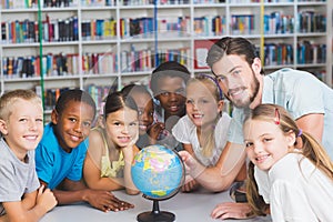 Pupils and teacher looking at globe in library