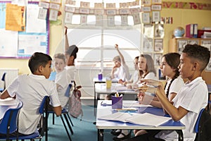Pupils turning round in lesson at primary school, side view