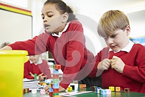 Pupils Working With Coloured Blocks In Maths Lesson