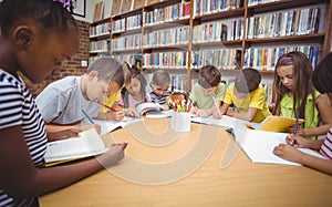 Pupils working together at desk in library