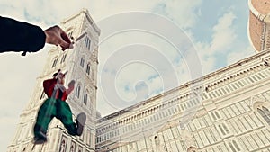 Puppet Pinocchio walking in front of the cathedral of Florence Italy