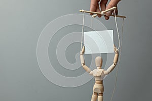 Puppeteer rules the doll on the ropes which holds the poster. The concept of rally or demonstration with provocateur activist photo