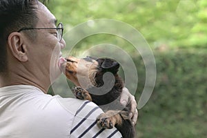 Puppy dog lick adult male on his face