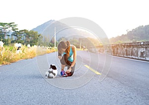 Puppy dog and young women running exercise on the street park in the morning. Young woman teaching her puppy dog obedience gesturi