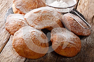 Pupular street food Bunuelos sprinkled with powdered sugar close-up. horizontal photo