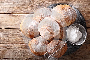 Pupular street food Bunuelos sprinkled with powdered sugar close-up. horizontal top view photo