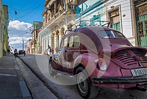 A purble oldtimer beetle in the streets of santiago de cuba