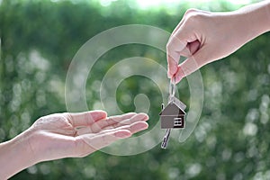 Purchase house, Realtor agent giving a key to buyer tenant on natural green background, New home and Real estate trading concepts