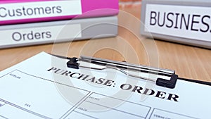 Purchase order form on wooden table with business files