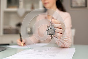 Purchase of real estate. Realtor shows keys. Close-up of hand and documents. Concept of leasing and mortgage
