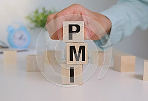 Purchasing Managers Index concept. Text PMI on wood cube. Index used as indicator of economic health of manufacturing and service