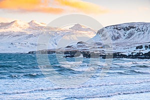 Pure blue ocean water at sunset, Ocean coastline with mountains, Winter landscape with snow, clouds and stormy sea