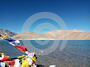 Pure Blue Pangong tso (Lake) and colorful religious flags