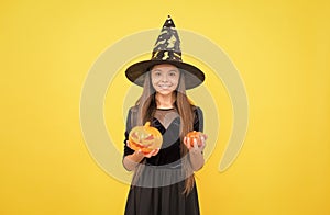 pure enchantress. jack o lantern. halloween witch girl. happy childhood. teenage child in witch hat. cheerful kid