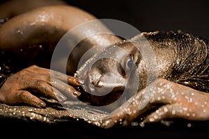 Pure gold. Golden lady relaxing. Vogue and glamour concept. Golden skin. Sexy girl face makeup body art metallized color