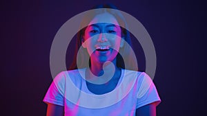 Pure happiness. Young happy korean woman laughing to camera, feeling positive and cheerful, posing in purple neon lights