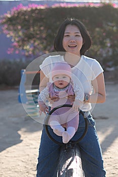 pure joy as a young Asian Chinese mother lovingly plays with her little baby girl, creating a lasting affection happiness bond -