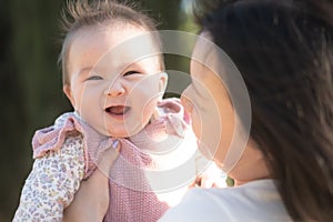 pure joy as a young Asian Korean mother lovingly plays with her little baby girl, creating a lasting affection happiness bond -