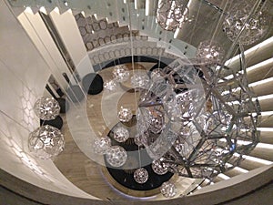 Pure luxury of interior design, spiral stairs and spherical chandelier hanging above