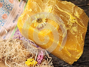 Pure natural beeswax raw block with countryside wild flowers.