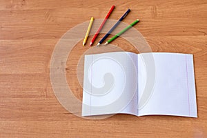 Pure noteboks and colorful pencils on the wooden desk. Concept of school education photo