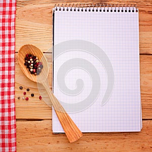 Pure notebook for recording menu, recipe on red checkered tablecloth tartan.