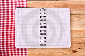 Pure notebook for recording menu, recipe on red checkered tablecloth tartan.