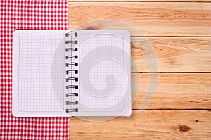 Pure notebook for recording menu, recipe on red checkered tablecloth tartan.