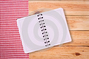 Pure notebook for recording menu, recipe on red checkered tablecloth tartan.