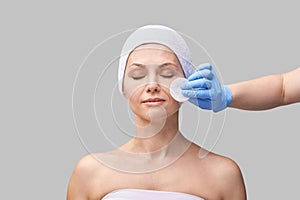 Pure skin care mature beauty portrait. Demakeup using cotton pad. Cosmetology photo